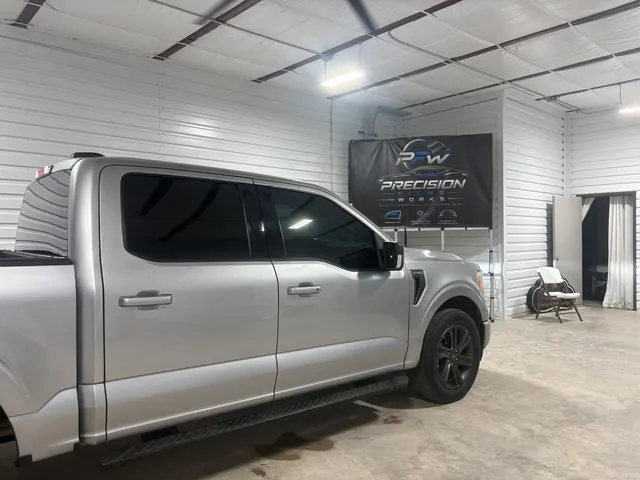 Silver pickup with tinted windows inside Precision Film Works
